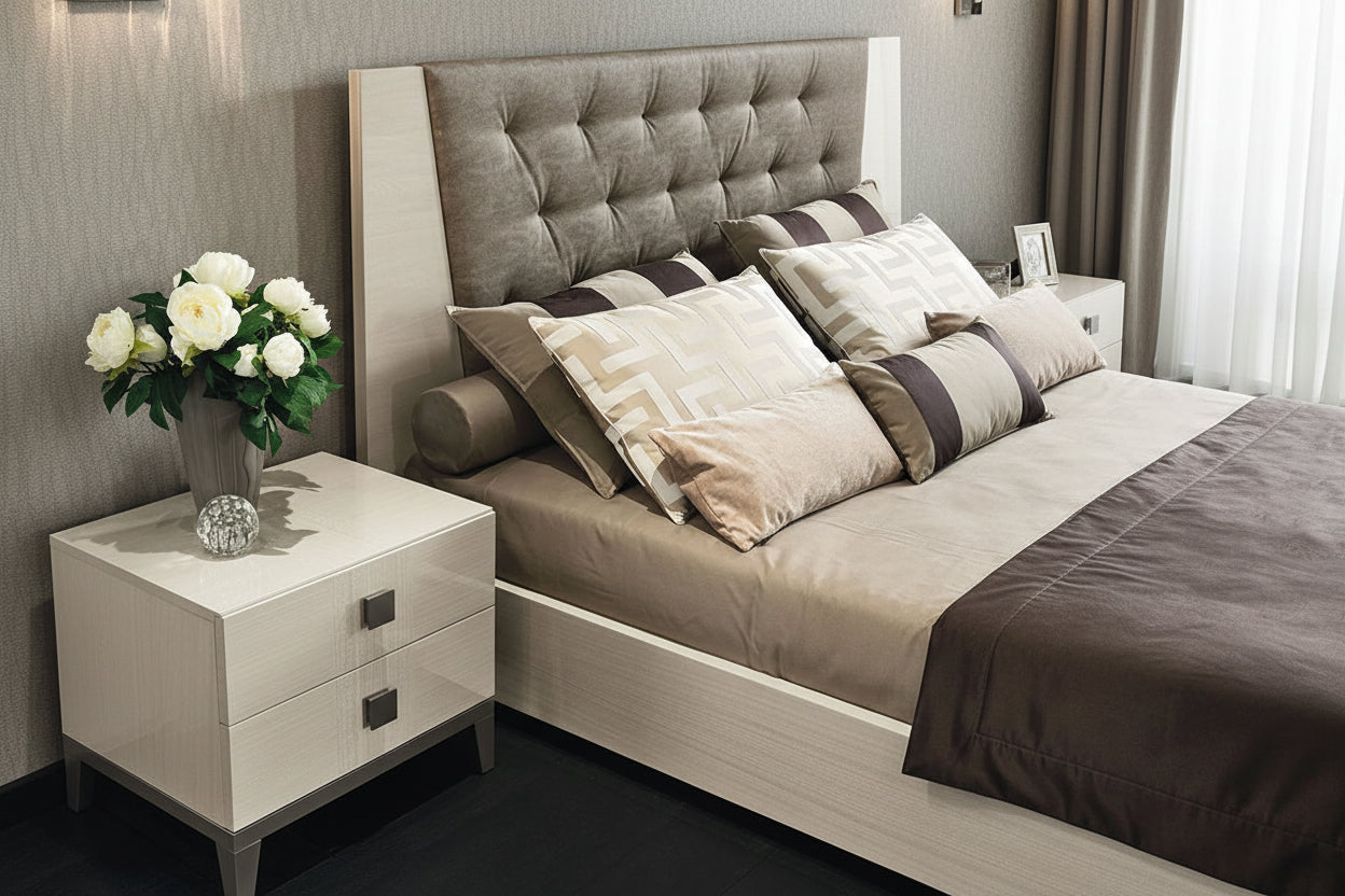 Neatly made Mont Blanc bed with a tufted headboard and a nightstand with flowers in a bedroom setting.