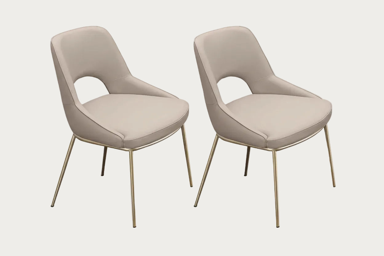 Two Amelia beige chairs with champagne-finished legs on a white background