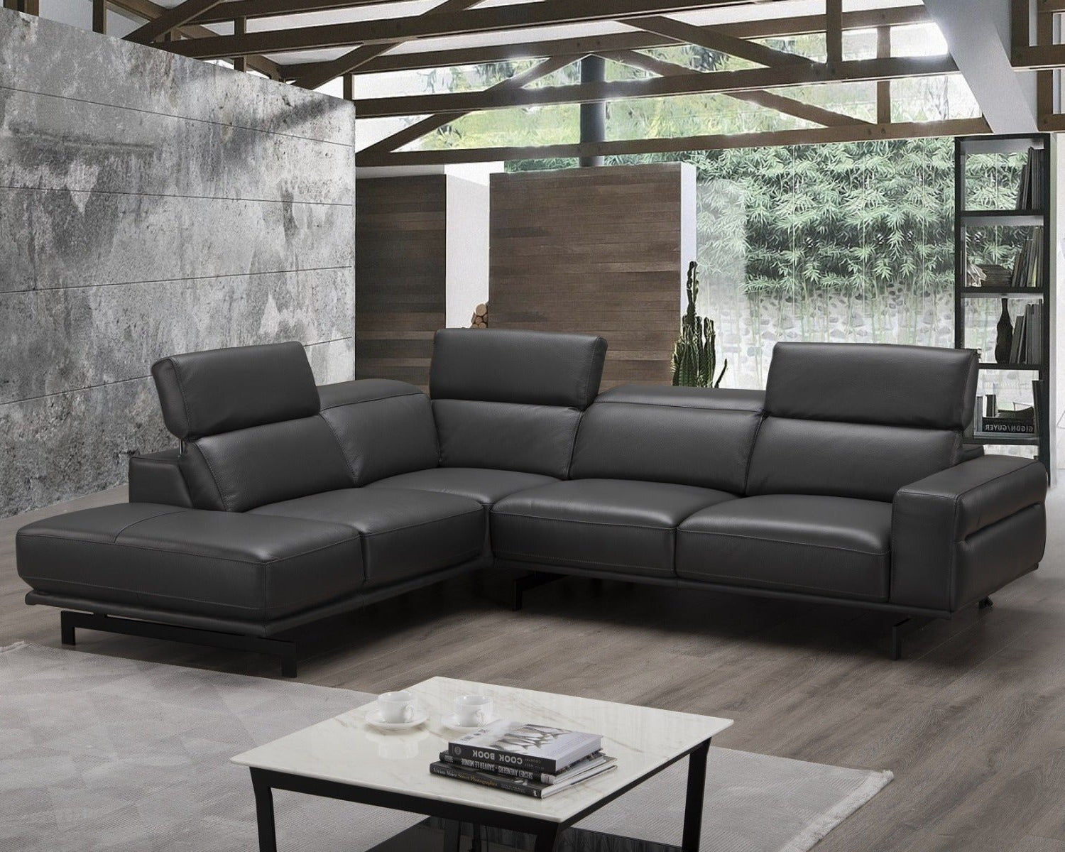 Modern black leather sectional sofa in a living room setting with a coffee table and decor.
