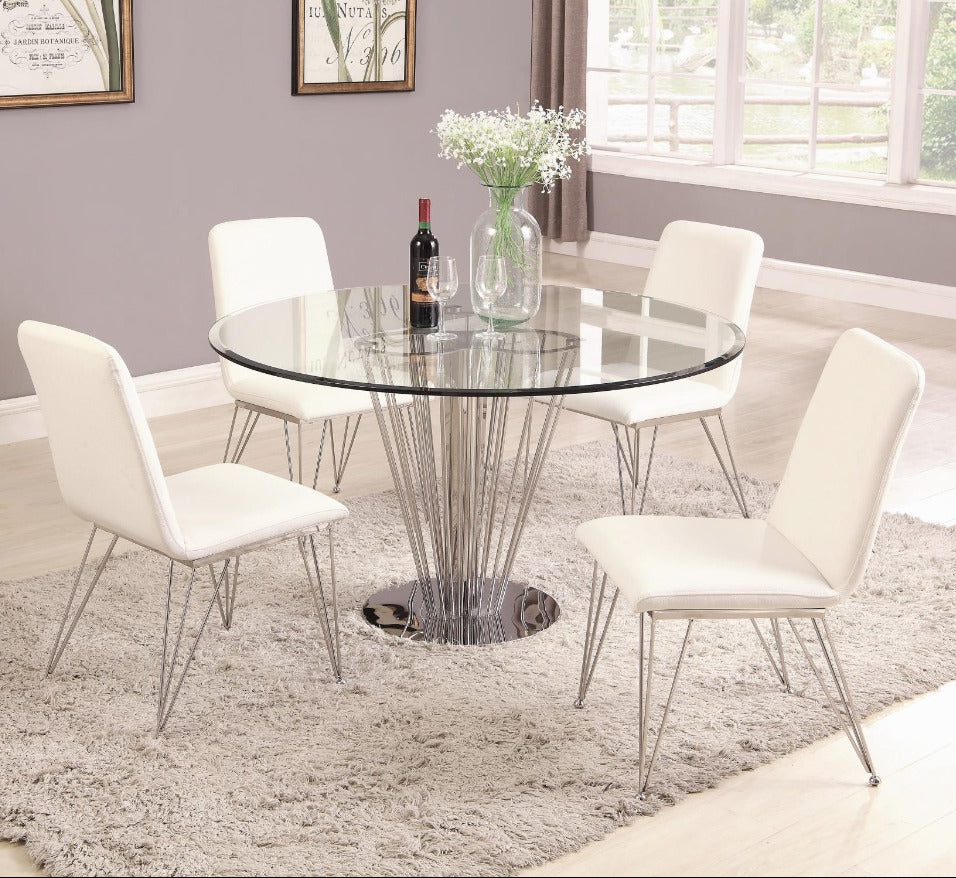 The Fernanda dining room with a round glass table and white chairs on a gray rug.