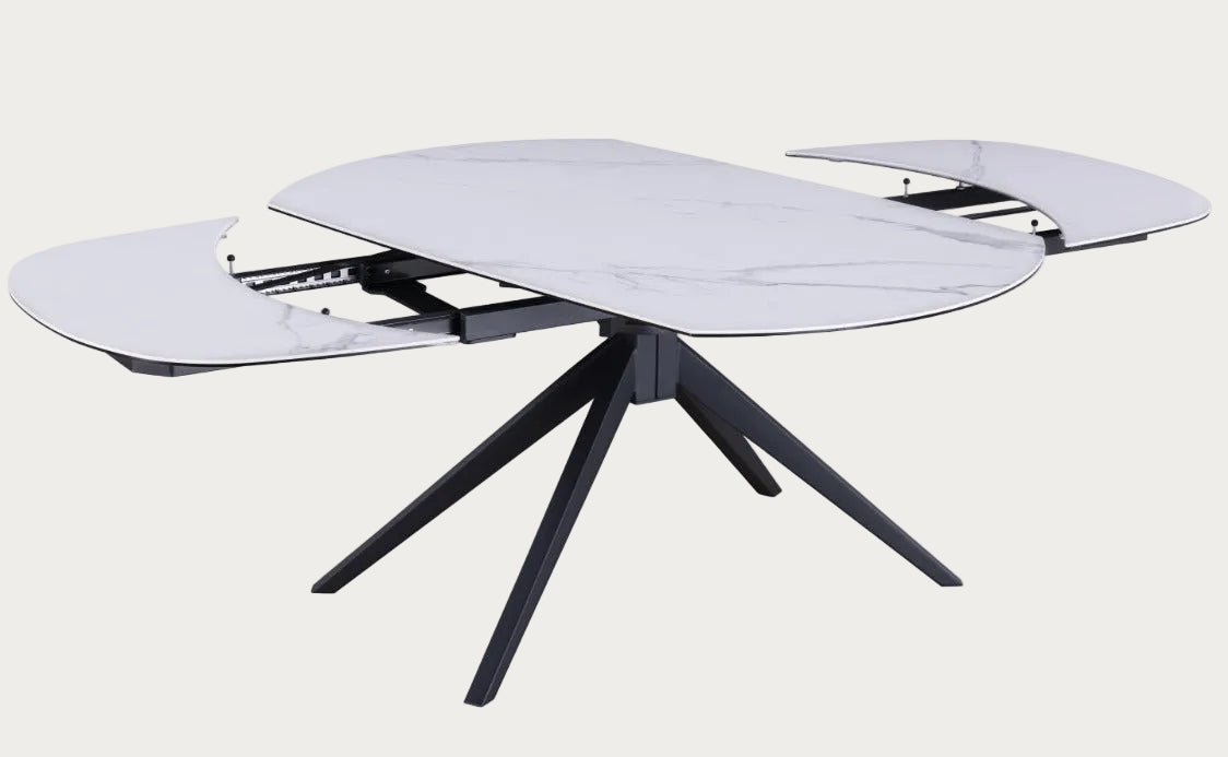 Extendable glass dining table with black metal legs on a white background